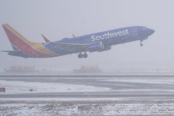 A Southwest Airlines plane takes off as the snow plows clear runways afar Friday, Jan 10, 2025, in Nashville, Tenn. (AP Photo/George Walker IV)