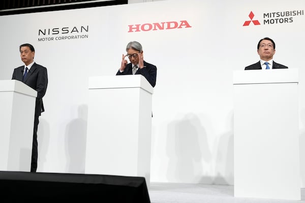 Nissan Chief Executive Makoto Uchida, left, and Honda Chief Executive Toshihiro Mibe, center, and Takao Kato CEO of Mitsubishi Motors, right, attend a joint news conference Monday, Dec. 23, 2024, in Tokyo, Japan. (AP Photo/Eugene Hoshiko)