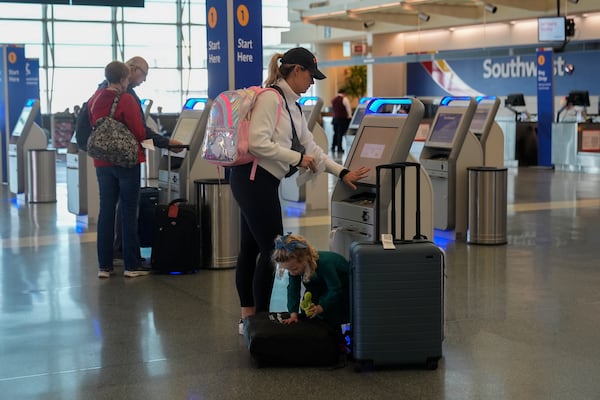 Travelers use Southwest Airlines kioks to check bags at Midway International Airport, Tuesday, March 11, 2025, in Chicago. (AP Photo/Erin Hooley)