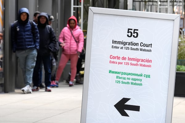 FILE - People wait in a cue before being led into a downtown Chicago building where an immigration court presides Tuesday, Nov. 12, 2024, in Chicago. (AP Photo/Charles Rex Arbogast, File)