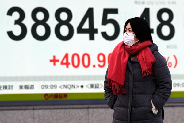 A person walks in front of an electronic stock board showing Japan's Nikkei index at a securities firm Thursday, Jan. 16, 2025, in Tokyo. (AP Photo/Eugene Hoshiko)