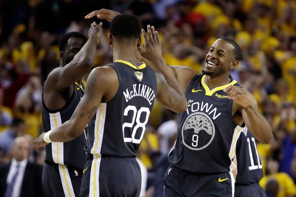 FILE _ Golden State Warriors forward Draymond Green, left, celebrates with forward Alfonzo McKinnie (28) and forward Andre Iguodala (9) during the first half of Game 6 of basketball's NBA Finals against the Toronto Raptors in Oakland, Calif., Thursday, June 13, 2019. (AP Photo/Ben Margot, File)