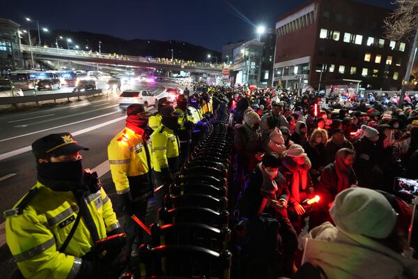 Supporters of impeached South Korean President Yoon Suk Yeol stage a rally to oppose a court having issued a warrant to detain Yoon, as police offices stand guard near the presidential residence in Seoul, South Korea, Friday, Jan. 3, 2025. (AP Photo/Lee Jin-man)