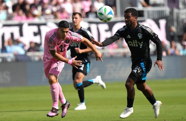 Inter Miami forward Luis Suarez (9) and Charlotte FC defender Nathan Byrne, right, go for the ball during the first half of an MLS soccer match, Sunday, March 9, 2025, in Fort Lauderdale, Fla. (AP Photo/Lynne Sladky)