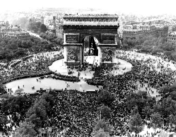 FILE - Thousands celebrate the announcement of Germany's unconditional surrender to the Allies in World War II, on May 7, 1945, at the Arc de Triomphe in Paris on VE Day. (AP Photo/File)