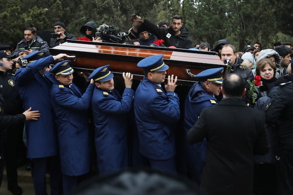 Pilots carry a coffin during a funeral of the crew members of the Azerbaijan Airlines Embraer 190 killed in a deadly plane crash in Kazakhstan this week, at the II Alley of Honor in Baku, Azerbaijan, Sunday, Dec. 29, 2024. (AP photo)