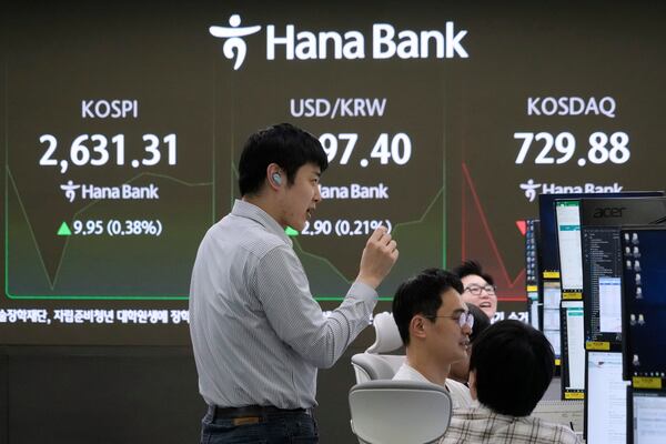Currency traders work near a screen showing the Korea Composite Stock Price Index (KOSPI), top left, and the foreign exchange rate between U.S. dollar and South Korean won, top center, at the foreign exchange dealing room of the KEB Hana Bank headquarters in Seoul, South Korea, Friday, May 16, 2025. (AP Photo/Ahn Young-joon)