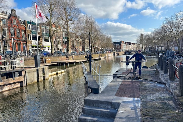 Rashid Ouchene opens the lock in Utrecht, Netherlands, Tuesday, March 11, 2025, where a "fish doorbell" was installed that lets viewers of an online livestream alert authorities to fish being held up as they make their springtime migration to shallow spawning grounds. (AP Photo/Aleksandar Furtula)