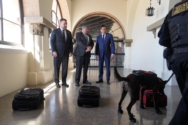 U.S. Ambassador Tobin Bradley, from left, Guatemalan Interior Minister Francisco Jiménez, and U.S. Secretary of State Marco Rubio, watch a simulation of a sniffer dog trained to find narcotics, at La Aurora International Airport in Guatemala City, Wednesday, Feb. 5, 2025. (AP Photo/Mark Schiefelbein, Pool)