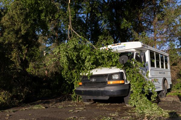 A tree branch covers a bus in Dorr, Mich., after a severe storm ripped across Michigan the night before, on Friday, May 16. 2025. (Neil Blake /The Grand Rapids Press via AP)