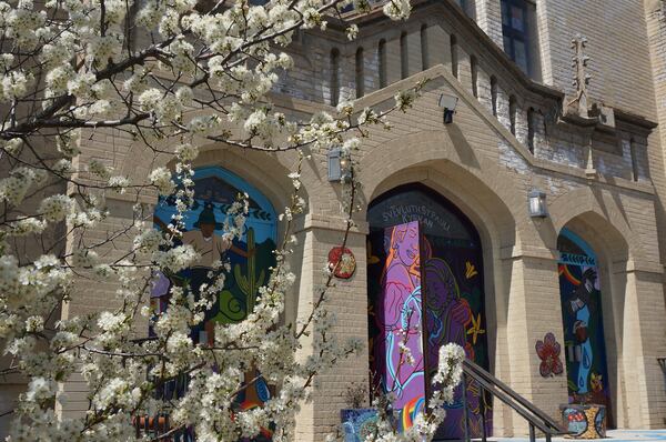 Spring blossoms bloom on a tree next to the entrance of St. Paul’s-San Pablo Lutheran Church, a congregation founded by Swedish immigrants in the late 19th century that has started offering wellness programs in its sanctuary as part of its migrant ministry, in Minneapolis, Sunday, April 27, 2025. (AP Photo/Giovanna Dell’Orto)