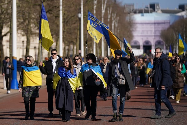 Ukrainian supporters waving flags and banners walk down the Mall as Britain's Prime Minister Keir Starmer chairs a Ukraine Summit at Lancaster House in London, Sunday, March 2, 2025. (AP Photo/Alberto Pezzali)