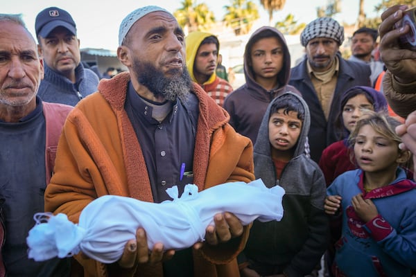 Imam Islam Abu Suaied holds the body of 20-day-old Jomaa al-Batran , who died from hypothermia, before the funeral at Al-Aqsa Martyrs Hospital in central Gaza, Sunday, Dec. 29, 2024. Jomaa's twin brother, Ali, remains in intensive care, as local health officials report at least three other infant deaths from the cold in recent weeks. (AP Photo/Abdel Kareem Hana)