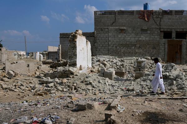 A resident walks through the rubble of homes damaged by last year's territorial rains, in Gwadar, Pakistan, Monday, Jan. 13, 2025. (AP Photo/Anjum Naveed)