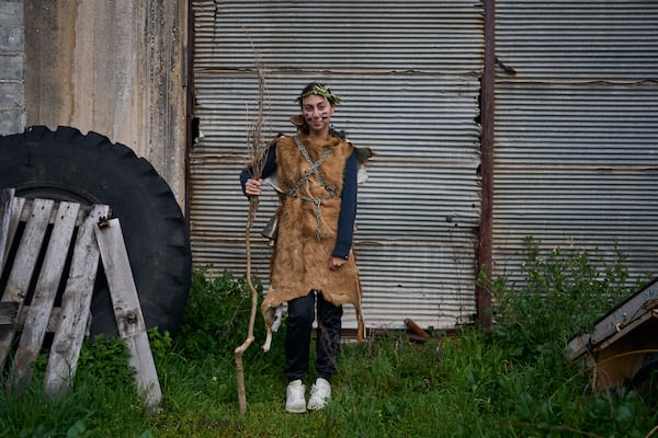 Panagiota Statha, 16, poses for a portrait, dressed in animal skins and heavy bronze bells, as part of carnival celebrations in Distomo, a village in central Greece, on Monday, March 3, 2025. (AP Photo/Petros Giannakouris)