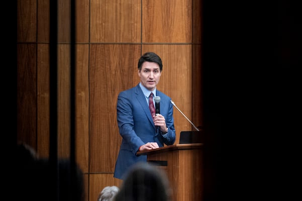 Canada's Prime Minister Justin Trudeau is pictured through glass as he speaks with members of his caucus in Ottawa, Ontario, on Monday, Dec. 16, 2024. (Spencer Colby/The Canadian Press via AP)