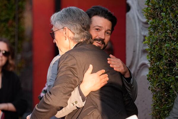Tony Gilroy, left, and Diego Luna embrace at a launch event of the second season of "Andor" on Monday, April 14, 2025, at the El Capitan Theatre in Los Angeles. (AP Photo/Chris Pizzello)