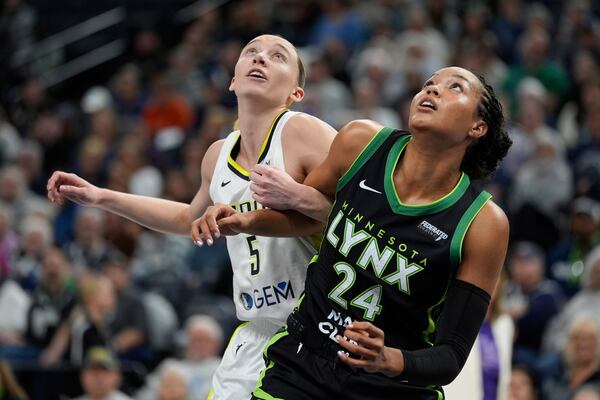 Dallas Wings guard Paige Bueckers (5) and Minnesota Lynx forward Napheesa Collier (24) watch for a rebound during the first half of a WNBA basketball game Wednesday, May 21, 2025, in Minneapolis. (AP Photo/Abbie Parr)