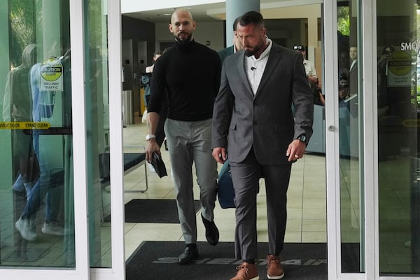 Influencer Andrew Tate, left, arrives, Thursday, Feb. 27, 2025, in Fort Lauderdale, Fla. Andrew and his brother Tristan were charged with human trafficking in Romania and arrived in the U.S. after authorities lifted travel restrictions. (AP Photo/Marta Lavandier)