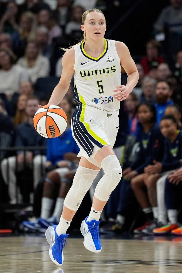 Dallas Wings guard Paige Bueckers (5) dribbles down the court during the first half of a WNBA basketball game against the Minnesota Lynx, Wednesday, May 21, 2025, in Minneapolis. (AP Photo/Abbie Parr)