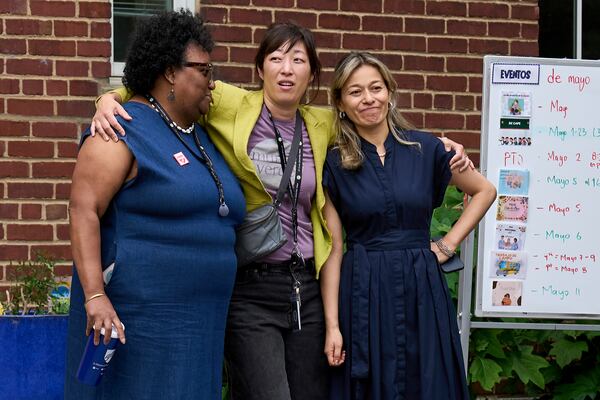 Staff at Mundo Verde Public Charter School hug as staff and parents keep watch for Immigration and Customs Enforcement (ICE) agents amid fears of impending arrests at schools, Tuesday, May 6, 2025. (AP Photo/Jacquelyn Martin)