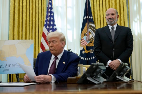 Commerce Secretary nominee Howard Lutnick listens as President Donald Trump speaks after signing an executive order in the Oval Office of the White House, Thursday, Feb. 13, 2025, in Washington. (AP Photo/Ben Curtis)