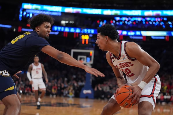 Marquette's Royce Parham, left, defends St. John's's RJ Luis Jr. (12) during the first half of an NCAA college basketball game in the semifinals of the Big East tournament Friday, March 14, 2025, in New York. (AP Photo/Frank Franklin II)