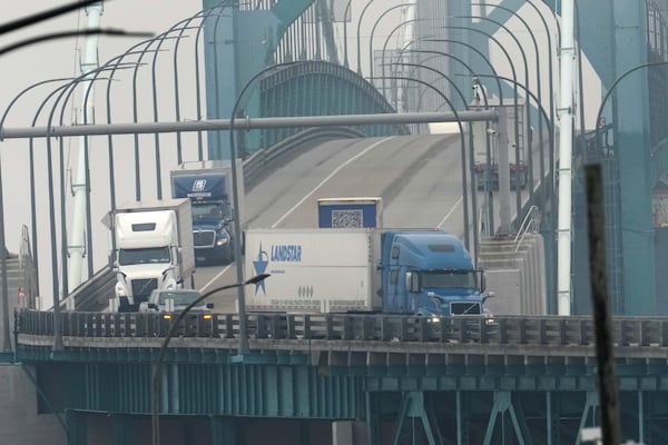 Trucks enter into the United States from Ontario, Canada across the Ambassador Bridge, Monday, Feb. 3, 2025, in Detroit. (AP Photo/Paul Sancya)