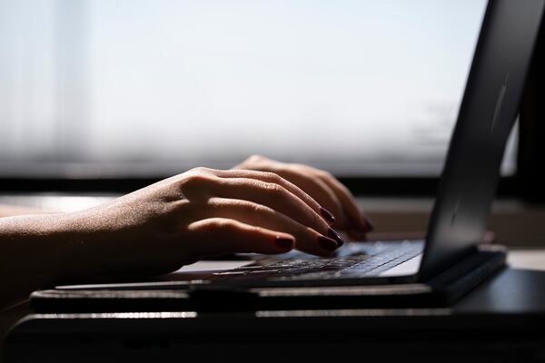 FILE - This May 18, 2021, photo shows a woman typing on a laptop on a train in New Jersey. Record numbers of people are starting new businesses, and more and more of them are women and minorities, according to a new study. (AP Photo/Jenny Kane, File)