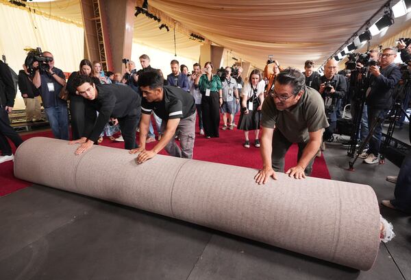 Crew members roll out the red carpet for Sunday's 97th Academy Awards at the Dolby Theatre on Wednesday, Feb. 26, 2025, in Los Angeles. (AP Photo/Chris Pizzello)