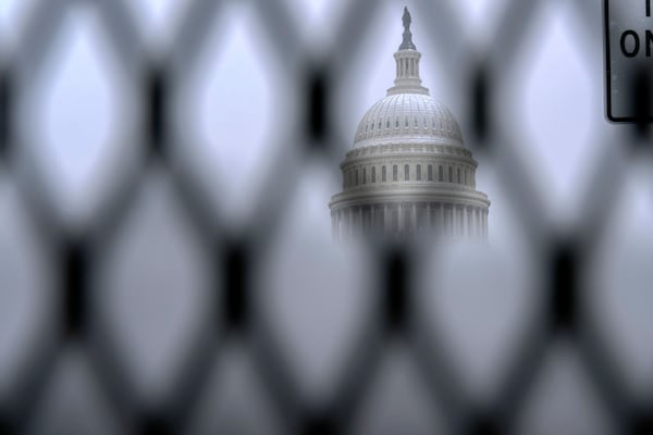 The Capitol is seen through a security fence as snow blankets Capitol Hill ahead of a joint session of Congress to certify the votes from the Electoral College in the presidential election in Washington, Monday, Jan. 6, 2025. (AP Photo/Jose Luis Magana)