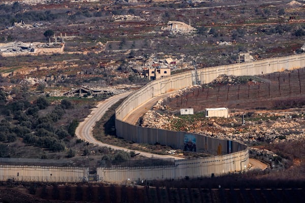 A wall marks the Israeli-Lebanese border near the village of Odaisseh in southern Lebanon, as seen from northern Israel, Thursday, Jan. 23, 2025. (AP Photo/Ariel Schalit)