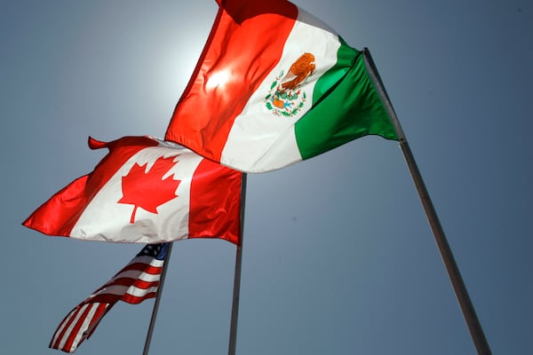 FILE - National flags representing the United States, Canada, and Mexico fly in the breeze in New Orleans where leaders of the North American Free Trade Agreement met on April 21, 2008. (AP Photo/Judi Bottoni, File)