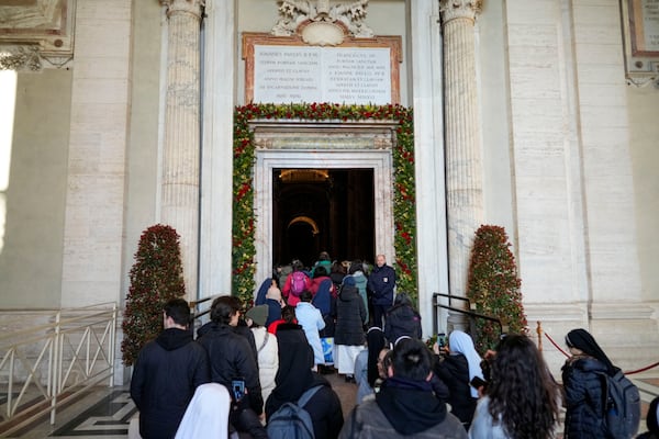 Faithful walk through the Holy Door of St.Peter's Basilica at the Vatican, Wednesday, Dec. 25, 2024, after it was opened by Pope Francis on Christmas Eve marking the start of the Catholic 2025 Jubilee. (AP Photo/Andrew Medichini)