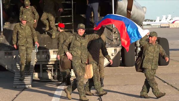 In this photo taken from video released by Russian Defense Ministry Press Service on Saturday, May 24, 2025, Russian servicemen leave a plane upon arrival to Chkalovsky airport, outside Moscow, Russia, after returning from captivity by a POWs exchange between Russia and Ukraine. (Russian Defense Ministry Press Service photo via AP)