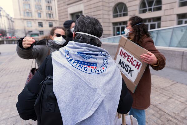 Contract workers for United States Agency for International Development, or USAID, hug outside the USAID headquarters in Washington, Monday, Feb. 10, 2025. (AP Photo/Manuel Balce Ceneta)