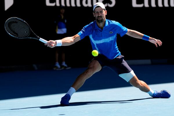 Novak Djokovic of Serbia plays a forehand return to Alexander Zverev of Germany during their semifinal match at the Australian Open tennis championship in Melbourne, Australia, Friday, Jan. 24, 2025. (AP Photo/Ng Han Guan)