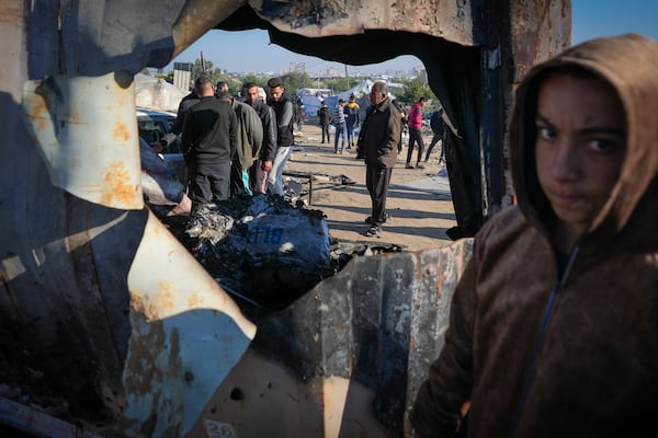 Palestinians inspect the site of an earlier Israeli army strike in the Muwasi area, in Khan Younis, central Gaza Strip, Thursday Jan. 2, 2025. According to Palestinian medical officials, the airstrike killed at least 10 people, including three children and two senior police officers, in an Israeli-designated humanitarian zone in the Gaza Strip. (AP Photo/Abdel Kareem Hana)