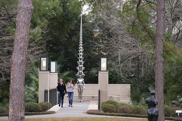 Visitors walk past Karma, Do-Ho Sue, brushed stainless steel and stone base, 2011, at the Sydney and Walda Besthoff Sculpture Garden in City Park in New Orleans, Wednesday, Jan. 29, 2025. (AP Photo/Gerald Herbert)