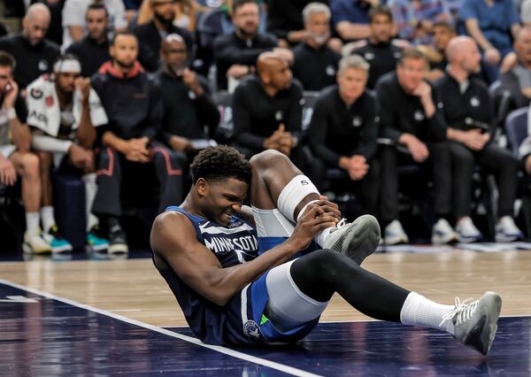 Minnesota Timberwolves guard Anthony Edwards (5) grabs his leg on the court during the first half of Game 2 of an NBA basketball second-round playoff series against the Golden State Warriors, Thursday, May 8, 2025, in Minneapolis. (Carlos Avila Gonzalez/San Francisco Chronicle via AP)