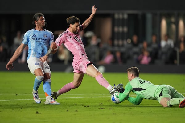 Inter Miami forward Lionel Messi (10) tries unsuccessfully to score, defended by New York City FC goalkeeper Matt Freese, right, and New York City FC midfielder Andres Perea (8) during the second half of an MLS soccer match, Saturday, Feb. 22, 2025, in Fort Lauderdale, Fla. (AP Photo/Rebecca Blackwell)