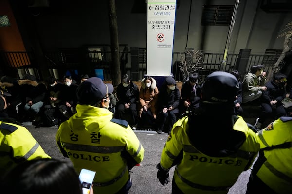 Police officers stand in front of supporters of impeached South Korean President Yoon Suk Yeol after they illegally climbed over a fence inside the Seoul Western District Court in Seoul, South Korea, Saturday, Jan. 18, 2025. (AP Photo/Ahn Young-joon)