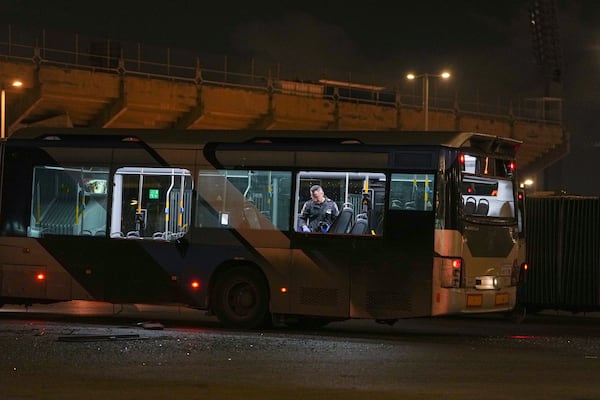 An Israeli police officer inspect the scene where police have reported a series of explosions on buses in what they said appeared to be a militant attack in Bat Yam, central Israel, Thursday Feb. 20, 2025. No injuries were reported. (AP Photo/Ohad Zwigenberg)