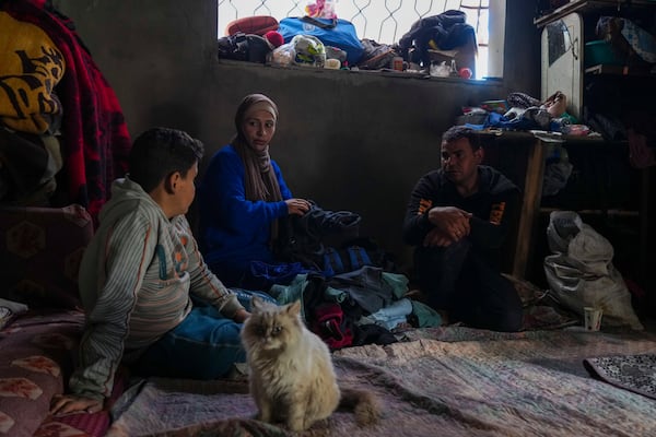 Members of the Tamboura family sit in their home, which was struck by an Israeli airstrike on Oct. 20, 2023, in Beit Lahiya, northern Gaza Strip, Friday, Feb. 21, 2025. (AP Photo/Abdel Kareem Hana)