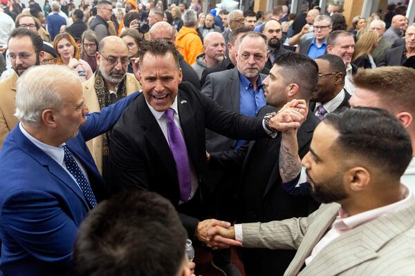 Genesee County Sheriff Chris Swanson is embraced as he announces his campaign to run for governor of Michigan in the 2026 election Thursday, Feb. 6, 2025, at Mott Community College in Flint, Mich. (Jake May/The Flint Journal via AP)