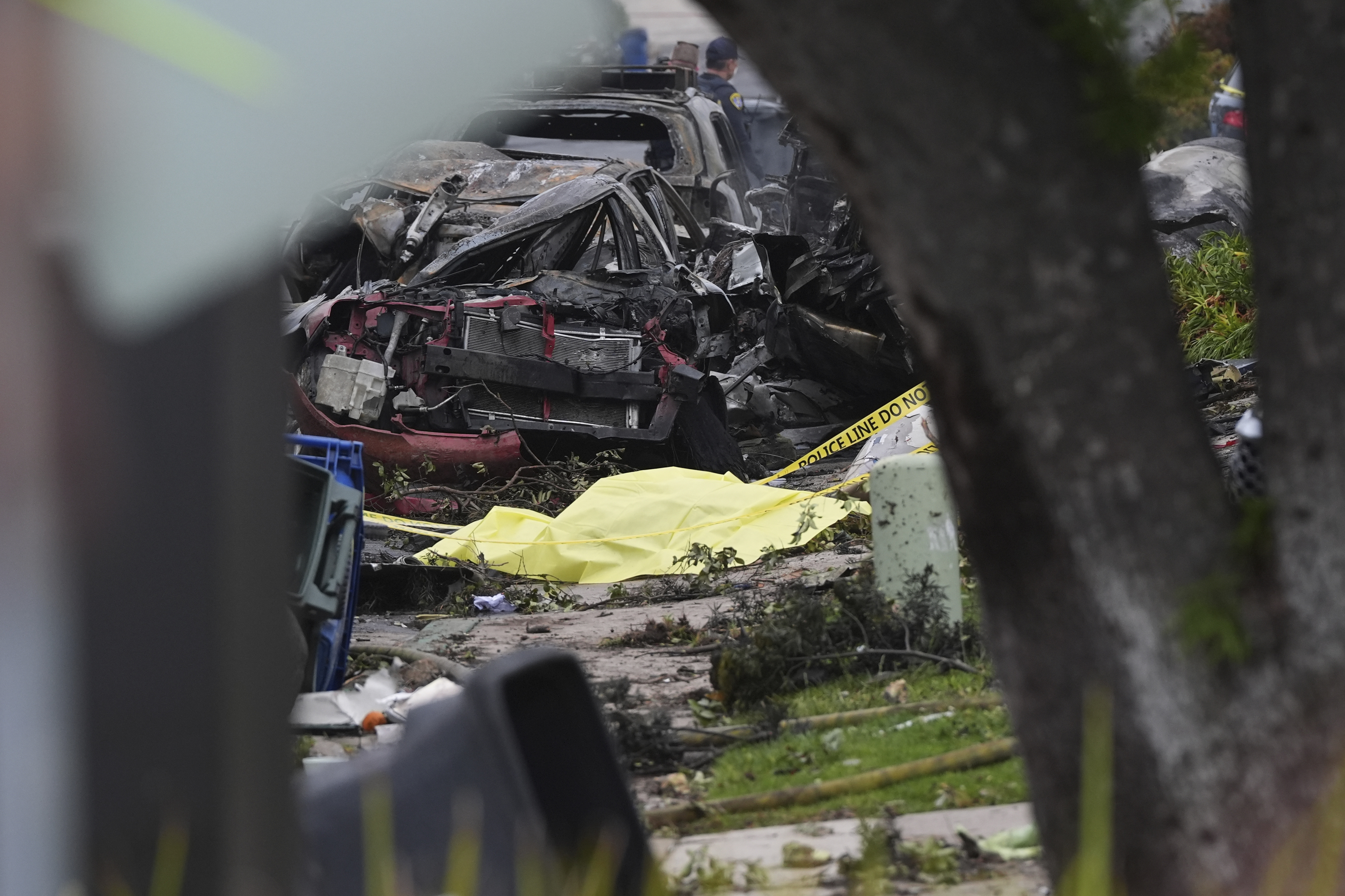 Authorities work the scene where a small plane crashed into a San Diego neighborhood, setting several homes on fire and forcing evacuations along several blocks early Thursday, May 22, 2025. (AP Photo/Gregory Bull)