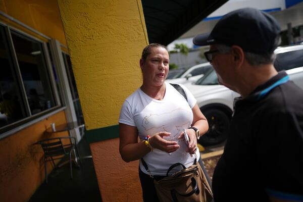 Surianny Iriarte, 47, a lawyer and political activist for Venezuela's opposition until death threats forced her to flee in 2015, talks to one of her countrymen following a press conference by Venezuelan community leaders to denounce changes to the protections that shielded hundreds of thousands of Venezuelans, including Iriarte, from deportation, Monday, Feb. 3, 2025, in Doral, Fla. (AP Photo/Rebecca Blackwell)