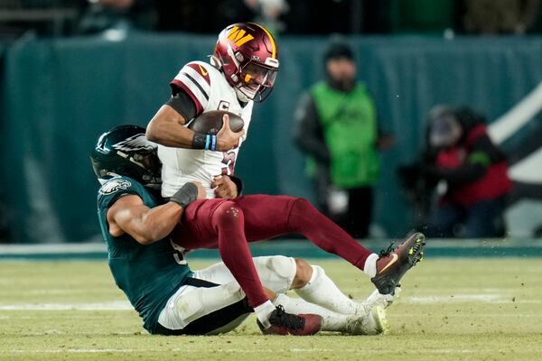 Washington Commanders quarterback Jayden Daniels is sacked by Philadelphia Eagles linebacker Nolan Smith Jr. during the second half of the NFC Championship NFL football game, Sunday, Jan. 26, 2025, in Philadelphia. (AP Photo/Seth Wenig)