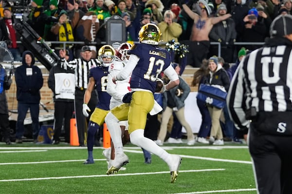 Notre Dame quarterback Riley Leonard (13) runs for a one-yard touchdown against Indiana for a during the second half in the first round of the NCAA College Football Playoff, Friday, Dec. 20, 2024, in South Bend, Ind. (AP Photo/Darron Cummings)