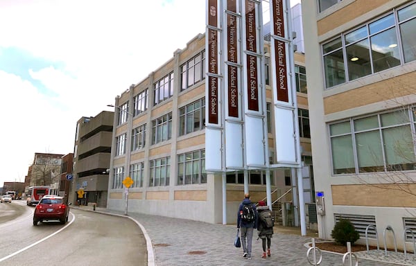 FILE - Pedestrians make their way past a building housing the Warren Alpert Medical School of Brown University, Jan. 30, 2019, in Providence, R.I. (AP Photo/Jennifer McDermott, File)